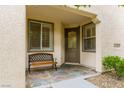 Cozy front porch with bench seating, decorative tile flooring, and a stylish, wood-framed glass front door at 4496 Largo Cantata St, Las Vegas, NV 89135