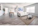 Bright, staged living room boasts modern decor, light wood floors, neutral colors, and natural light from the large windows at 45 Maleena Mesa St # 327, Henderson, NV 89074