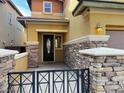 Close up of the front entrance featuring stone accents and a secure wrought-iron gate for added curb appeal at 5361 Candlespice Way, Las Vegas, NV 89135