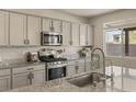 Modern kitchen featuring granite countertops, stainless steel appliances, and ample cabinet space at 7717 Rosebark Cliffs St, North Las Vegas, NV 89084