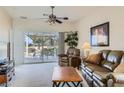 Comfortable living room boasts neutral walls, carpet, ceiling fan, and sliding door access to the patio at 7921 Fantail Dr, North Las Vegas, NV 89084