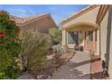 Inviting entrance with a well-manicured garden and covered front porch at 8432 Squaw Valley Ave, Las Vegas, NV 89128