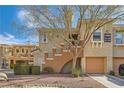 Charming townhome featuring an attached garage and quaint desert landscaping at 10800 Amber Ridge Dr # 103, Las Vegas, NV 89144