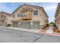 Multi-level home featuring multiple garage doors, landscaped surroundings, and a quaint balcony on the second level at 1150 Red Margin Ct # 101, Las Vegas, NV 89183