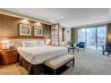 Comfortable bedroom with large bed, a lounge, and sliding glass doors to balcony at 125 E Harmon Ave # 2205, Las Vegas, NV 89109