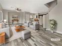 Staged living room features modern furniture, wood floors, and neutral paint palette at 1578 Ward Frontier Ln, Henderson, NV 89002