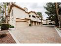 View of the home's exterior with multiple garage doors and ample parking at 2050 W Warm Springs Rd # 4322, Henderson, NV 89014