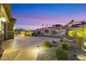 Long driveway featuring desert landscaping, retaining wall, and decorative ground lighting at 2491 Hardin Ridge Dr, Henderson, NV 89052