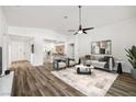 Bright, open-concept living room featuring wood flooring, contemporary furniture, and an abundance of natural light at 2648 E Sparrow Way, Pahrump, NV 89048