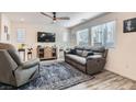 Comfortable living room features hardwood floors, neutral colors, a ceiling fan and large windows at 2773 Frosted Teal Ave, North Las Vegas, NV 89086