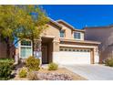 Inviting home with a two-car garage, mature tree, and rock landscaping in the front yard at 304 Iron Summit Ave, North Las Vegas, NV 89031