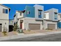 Striking exterior view of modern home with a two-car garage, accented by a red door and fresh landscaping at 3354 Via Strada St, Henderson, NV 89044