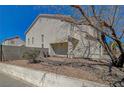 Side yard of home with low block wall, shade tree, and small patio at 3747 Gulliver St, Las Vegas, NV 89115
