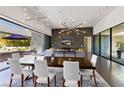 Open-concept dining room with modern lighting and seamless indoor-outdoor flow to patio at 4135 N Durango Dr, Las Vegas, NV 89129