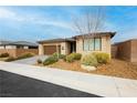 Single story home with desert landscaping including a decorative tree and rock ground covering at 4560 E Cactus Canyon Dr, Pahrump, NV 89061