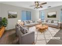 Bright living room featuring modern decor, plush seating, and a stylish ceiling fan with views from the large window at 6228 Grace Mountain St, Las Vegas, NV 89115