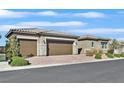 Beautiful home featuring a three-car garage and a well-maintained brick driveway at 6232 Lautman Ridge Ct, Las Vegas, NV 89141