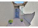 Inviting front entrance with a blue door, potted flowers, and decorative wreath at 6232 Lautman Ridge Ct, Las Vegas, NV 89141