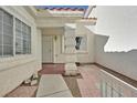 Inviting front entrance with a patterned tile patio and secure white metal security door at 7722 Top Hat Ave, Las Vegas, NV 89113