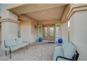 Inviting covered patio featuring tiled flooring, seating, and decorative blue planters at the entrance at 8093 Luna Sera Ave, Las Vegas, NV 89178