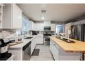 Well-lit kitchen features white cabinets, stainless steel appliances, and a large wooden island at 8890 Bonneville Peak Ct, Las Vegas, NV 89148