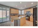 Bright kitchen features wood cabinets, granite countertops, an island, and stainless steel appliances at 9180 Wine Cellar Ave, Las Vegas, NV 89148