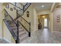Open foyer featuring tile flooring, a staircase with iron railing and a decorative glass front door at 12121 Cabo Rojo Ave, Las Vegas, NV 89138