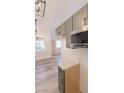 Open kitchen view showcases gray cabinets, stainless steel microwave, and wood-look flooring at 1624 N Torrey Pines Dr # 101, Las Vegas, NV 89108
