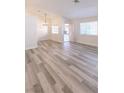 Open-concept living room boasts wood-look flooring, large windows and contemporary light fixture at 1624 N Torrey Pines Dr # 101, Las Vegas, NV 89108