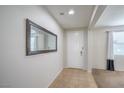 Bright entryway with neutral tile floors, white walls, and a decorative mirror at 3237 Mist Effect Ave, Henderson, NV 89044