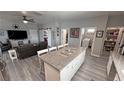 Open concept kitchen with large island, granite countertops, adjacent to living room, laundry room and pantry at 3341 S Big Sky Way, Pahrump, NV 89048