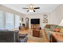 Inviting living room with wood floors, a large TV, a ceiling fan and a comfortable sofa at 3753 Heritage Ave, Las Vegas, NV 89121