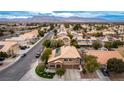 Expansive aerial view of a well-planned community featuring houses with tile roofs, solar panels, and mountain views at 4401 Lilac Glen Dr, Las Vegas, NV 89129