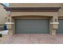 Exterior view of a two-car garage with brick paved driveway and well-maintained landscaping at 4625 Ridgeley Ave # 103, North Las Vegas, NV 89084