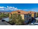 Apartment building showcasing the red tile roof, exterior paint colors, covered parking, and surrounding mountain views at 6160 Rumrill St # 201, Las Vegas, NV 89113