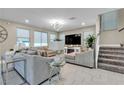 Inviting living room showcasing comfortable seating, large windows, and a staircase at 7333 Night Sky St, North Las Vegas, NV 89084