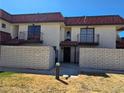 Stylish condo exterior with red tile roof, dual balconies, and brick privacy fence at 741 Bourbon St # E3, Pahrump, NV 89048
