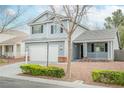 Charming two-story home with light blue siding, two-car garage, and cozy front porch at 7620 Whispering River St, Las Vegas, NV 89131