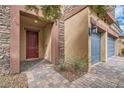 Inviting entryway with a brick path leading to a red door and attached two-car garage at 92 Tesla Ridge Way, Las Vegas, NV 89183