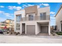 Contemporary two-story home showcases a balcony, two-car garage, and neutral color palette under a bright sky at 1790 Sparrow Song Ct, Las Vegas, NV 89138