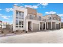 Modern two-story house with a balcony and two-car garage is situated on a clear, sunny day at 1790 Sparrow Song Ct, Las Vegas, NV 89138