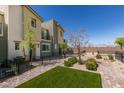 Landscaped exterior featuring an artificial lawn, plants and brick walkway leading up to the townhome at 2598 Mocha Pearl Ct, North Las Vegas, NV 89086