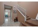 Entryway with stairwell, light-brown walls, tiled floor, and view into the living area at 33 Via Di Mello, Henderson, NV 89011