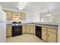 Functional kitchen layout featuring white appliances and light wood cabinets, ready for updates at 3400 Cabana Dr # 2103, Las Vegas, NV 89122