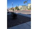 Exterior street view showcasing building's architectural details, desert landscaping, and proximity to community amenities at 7095 Burcot Ave # F83, Las Vegas, NV 89156