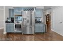 Kitchen boasting stainless steel appliances and blue cabinets, and hardwood floors at 7944 Marbella Cir, Las Vegas, NV 89128