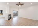 A living room with a fireplace, ceiling fan, a sliding glass door to a balcony, and wood look flooring at 9000 Las Vegas Blvd # 1043, Las Vegas, NV 89123