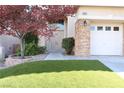 Home's front door and a well-maintained lawn and landscaping creating a welcoming curb appeal at 10657 Blue Nile Ct, Las Vegas, NV 89144