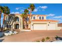 Beautiful home with a three-car garage, fountain, and a courtyard with palm trees at 117 Milton Ct, Boulder City, NV 89005