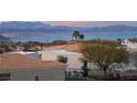 Expansive lake and mountain views surround this home featuring desert landscaping and a tiled roof at 117 Milton Ct, Boulder City, NV 89005